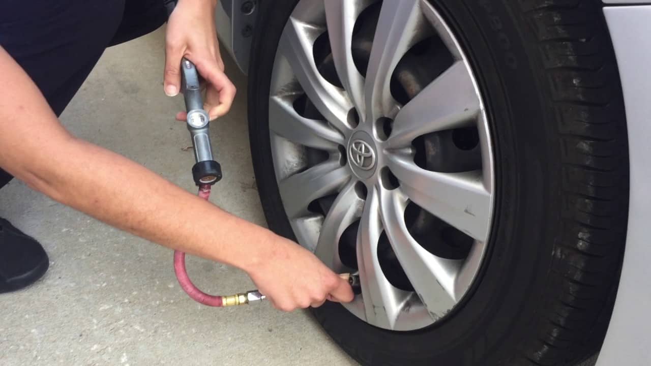 man checking tire pressure